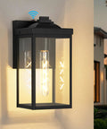 Two Pack Dusk To Dawn Sensor Outdoor Wall Lights, White Aluminum Sconce With Seed Glass lit up on house exterior