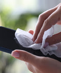 Hands using 70 Percent Isopropyl Alcohol Wipes For Your Electronics And Screens, 80 Count Per Pack In Sealed Canister to clean smartphone.