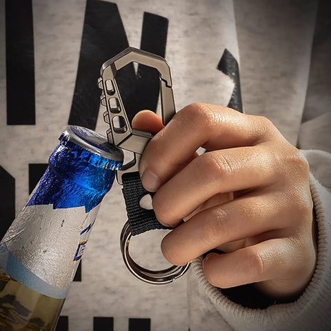 Hand using heavy duty key chain with bottle opener, tough car keychain set featuring metal snap hook carabiner clip, dual key rings and key storage, built tough for men and women, black finish, opening a bottle