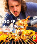 Person grilling meat and vegetables with tongs next to flames, text overlay "Up to 1000°F Ambient Temp"