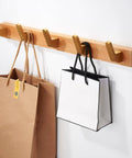 No Fuss Brass Wall Mount Coat Hooks Durable Entryway Hanger Rack with bags hanging on wooden wall mount in hallway.