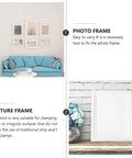 Living room with photo frames on the wall and a sofa; single picture frame on a shelf beside decorative items.