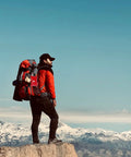 Small red 97-piece travel first aid kit attached to a hiking backpack on a mountain overlook.