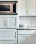 10 Pack 5 Inch Brushed Gold Cabinet Handles Premium Aluminum Zinc Alloy Hella Sleek Hardware Smooth Glide Action For Kitchen Cupboards Closets And Drawers installed on modern white kitchen cabinets.