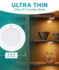 Stick On LED Puck Lights With Remote, Battery Powered Wireless Cabinet Lighting, 2 Pack, showing dimensions, on bookshelf