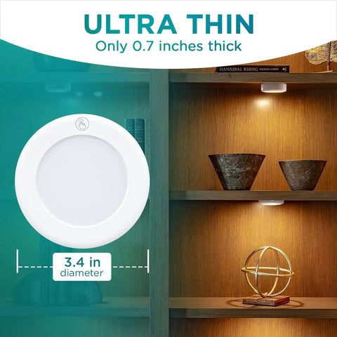 Stick On LED Puck Lights With Remote, Battery Powered Wireless Cabinet Lighting, 2 Pack, showing dimensions, on bookshelf