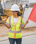 Woman wearing Mens Built Tough High Visibility Mesh Vest With Six Cargo Pockets And Secure Zipper Ansi Class Three top shelf safety wear.