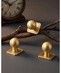 Slick Gold Zinc Alloy Cabinet Knobs With Premium Square Backplate And 1 Inch Round Ball Pulls For Kitchen Drawers Dressers Wardrobes Top Shelf Cupboard Furniture Hardware displayed on a wooden branch.