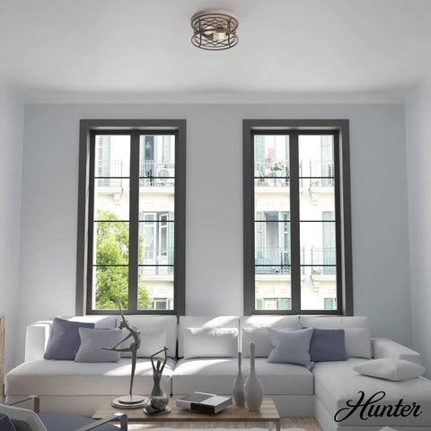 Round Rustic Flush Mount Ceiling Light In Onyx Bengal Finish in modern living room with large windows and white sofa