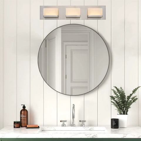 Everett 24 Inch Modern 3 Light Integrated LED Vanity Light with Brushed Nickel Finish above a bathroom mirror.
