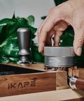 Hands using 53mm Gravity Adaptive Espresso Distributor for 54mm Portafilters, Fits Breville Bottomless Portafilter, 304 Stainless Steel Coffee Tool