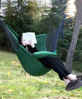 Two Cushions Included Hammock Chair With Soft Cotton Handwoven Fabric Indoor Outdoor Hanging Rope Swing For Bedroom Porch Patio Super Comfy Sturdy And Durable Lounge Chair with person reading outdoors.