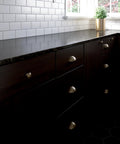 Kitchen cabinets with Champagne Bronze 3 Inch Cup Pull Cabinet Handles Set Of 10 For Cabinets And Dressers, 76mm, on dark wood drawers.