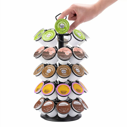 Hand placing k-cup on Compact K Cup Storage Carousel That Holds 45 Coffee Pods Five Tier Capsule Organizer Space Saving Black Display Stand For Keurig Pods Keeps Pods Neatly Sorted Easy Access Durable And Ready To Use