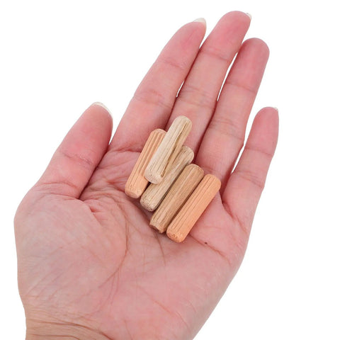 Hand holding beige M8x30mm wooden dowel pins for furniture assembly, showcasing solid round dowels for tables, chairs, cabinets.