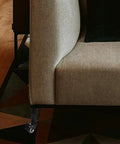 Close-up of Adjustable Sofa And Bed Leg Set With Caster Wheels, Cold Rolled Steel, installed on a beige couch corner.