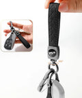 Heavy Duty Leather Carabiner Keychain With 360 Degree Rotating Snap Swivel Anti Lost D Ring And Woven Handmade Strap Microfiber Hand Strap Built For Everyday Carry Boss Level Durability For Men And Women Gunmetal Black shown in hand.