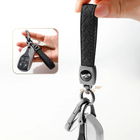 Heavy Duty Leather Carabiner Keychain With 360 Degree Rotating Snap Swivel Anti Lost D Ring And Woven Handmade Strap Microfiber Hand Strap Built For Everyday Carry Boss Level Durability For Men And Women Gunmetal Black shown in hand.