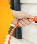 Person plugging Outdoor Extension Cord 25 Ft 16 Gauge SJTW Flexible Vinyl Jacket Bright Orange UL Listed into outlet.