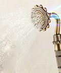 Antique Brass Exposed Shower System with Tub Spout 90° Rotating handheld showerhead spraying water close-up.