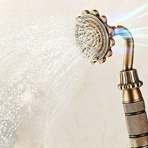Antique Brass Exposed Shower System with Tub Spout 90° Rotating handheld showerhead spraying water close-up.