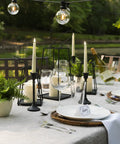Flameless Taper Candles Set With Realistic 3D Wick Flame, 7 Inch Ivory Wax, 4 Pack, on elegant outdoor dining table.