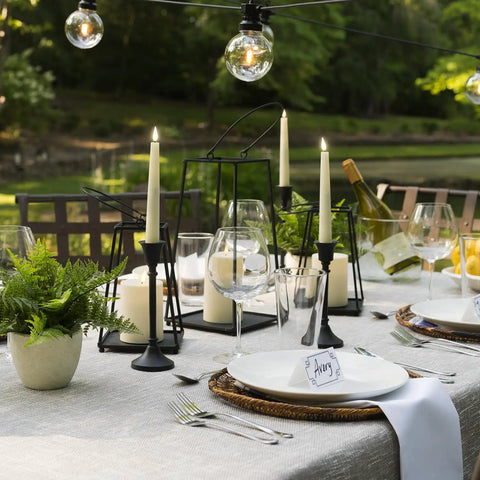 Flameless Taper Candles Set With Realistic 3D Wick Flame, 7 Inch Ivory Wax, 4 Pack, on elegant outdoor dining table.