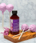 Bakery Emulsion Variety Pack For Cakes, Cookies And Desserts With Flavors Almond, Butter Vanilla, Lemon, Princess Cake And Cookie, Red Velvet, Strawberry Gluten Free And Keto Friendly, 4 Oz Bottles A Must Have For Home Bakers bottle with purple cake pops on a wooden board.