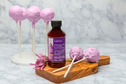 Bakery Emulsion Variety Pack For Cakes, Cookies And Desserts With Flavors Almond, Butter Vanilla, Lemon, Princess Cake And Cookie, Red Velvet, Strawberry Gluten Free And Keto Friendly, 4 Oz Bottles A Must Have For Home Bakers bottle with purple cake pops on a wooden board.