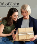 Two women smiling with Himalayan Salt Lamp Rectangle In Natural Pink Rock With Wood Base Dimmable Cord Night Light gift box.