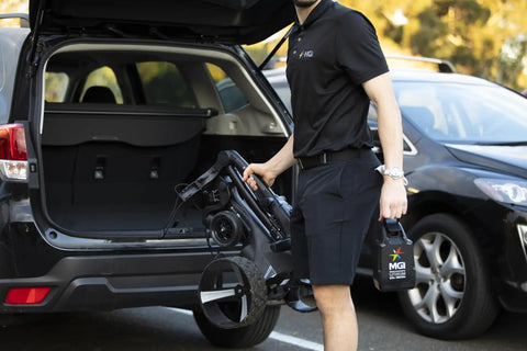 Person loading Remote Control Electric Golf Cart With All Terrain Drive And 36 Hole Lithium Battery into car trunk.