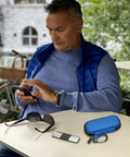 Hard Travel Case For KardiaMobile EKG Monitors 1 Lead 6L 6L Max With Pill Box Carabiner Clip on table near man using phone