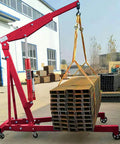 Red hydraulic long-ram jack with single-piston pump on a wheeled base, side view lifting a bundle of metal beams.