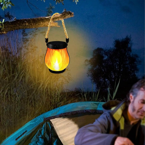 USB Charging Solar Lantern For Outdoors And Travel hanging from tree branch at campsite with soft glow