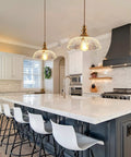 Slick Oil Rubbed Bronze One Light Pendant Ceiling Lamp With Retro Dome Glass Shade above a kitchen island with white bar stools.