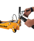 Professional Grade 14 Oz Pistol Grip Grease Gun With Heavy Duty Build used for lubricating equipment in an industrial setting.