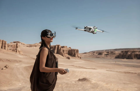 Person using Infinity Bundle 8K 360 Degree Foldable Drone With Immersive Goggles in desert landscape, drone in flight.