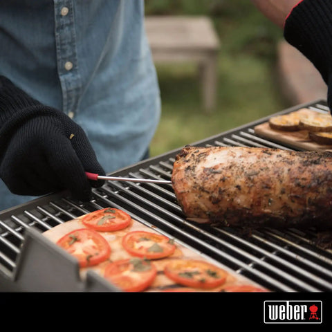 Person using iGrill Pro Stainless Steel Meat Probe With Four Color Coded Sleeves And Handy Storage Wrap For Simultaneous Monitoring Of Four Probes On iGrill Mini 2 And 3 Thermometers on grilled meat