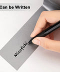 Person writing on Heavy Duty Waterproof Duct Tape 2 Inch By 30 Yards Six Roll Multipack For Indoor Outdoor Use, showing writeability.