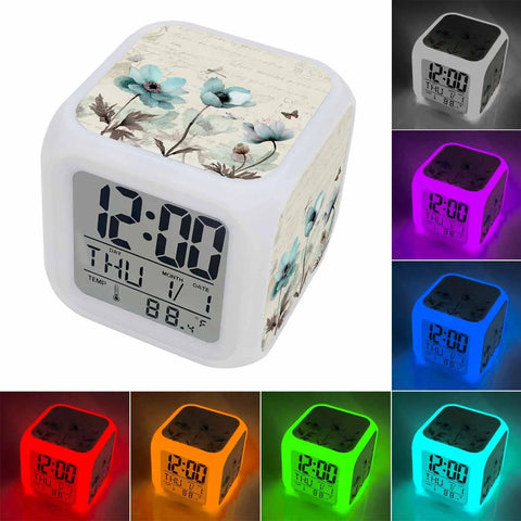 Works Like A Charm Digital Alarm Clock With Spring Blossom Cube Look displaying time and cool room temperature in multiple light colors.