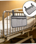 Bed Rail Organizer With Four Pockets And Cup Holder, Hanging Bedside Storage Caddy in gray fabric attached to hospital bed rail.