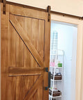 Dope Black Barn Door Handle Set For Sliding Doors And More installed on a wooden sliding door, showcasing sleek rustic steel hardware.