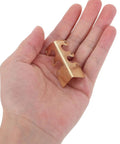 Hand holding 20 piece antique bronze corner protectors for tables and photo frames, alloy corner guards with prepunched holes