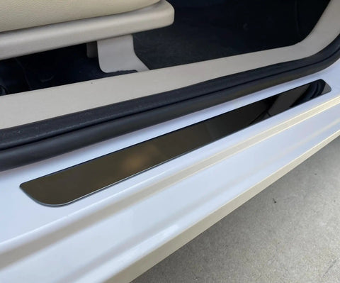 Badass Level Stainless Steel Door Sill Scuff Plate Guards For Rivian R1S R1T R2 shown on white vehicle entry step, protecting from scratches.