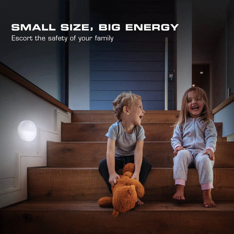 Two children sitting on stairs with a Motion Sensor Night Light With Auto On Off, No Fuss Cool White LED Path Light on the wall
