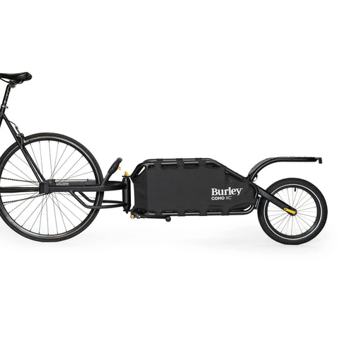 Coho XC Single Wheel Off Road Cargo Bike Trailer with coil spring suspension and quick release hitch attached to a bicycle.