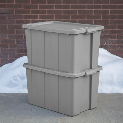 Tough As Nails 30 Gallon Storage Bins With Secure Lids stacked gray heavy duty plastic totes against brick wall.