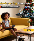 Child smiling on couch using remote for F47 RC Fighter Drone For Kids, super easy to fly with altitude hold and LED lights indoors.