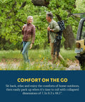 Couple carrying Comfort Pro Rocker Folding Outdoor Chair for Camping and Backyard Hangouts, collapsible and portable in indigo blue.