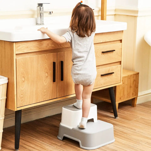 Child using Two Step Toddler Stool Set Of Two at sink, light grey color, easy access for potty training and washing.